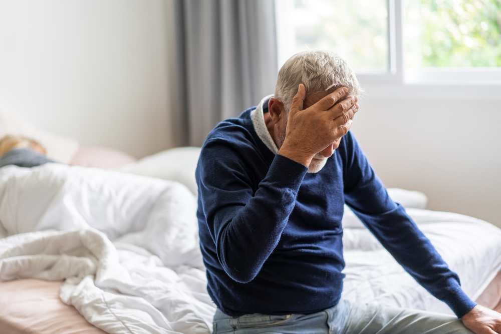 depressed-old-man-sitting-on-bed