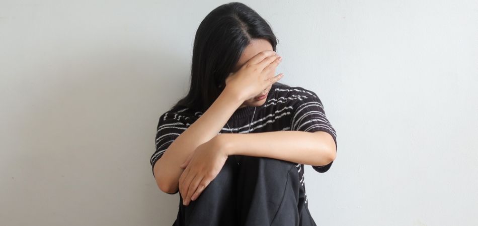 depressed woman sitting on the floor