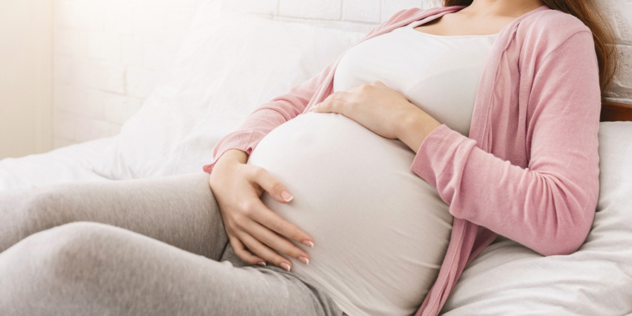 Pregnant woman lying on bed.