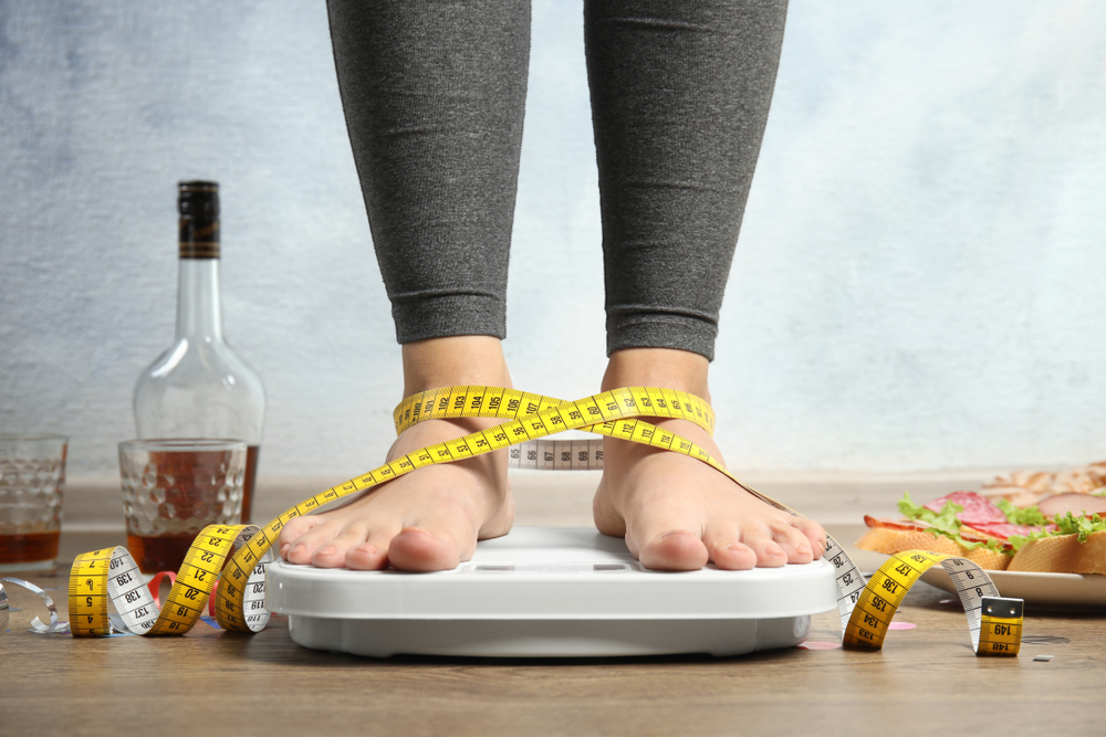 Woman with measuring tape and alcohol