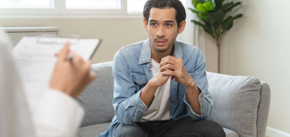 A man on a couch in addiction therapy