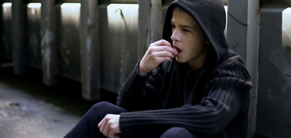 young and sad boy taking drugs