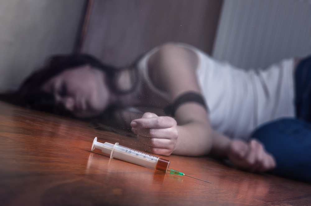 Woman lying on floor after taking heroin