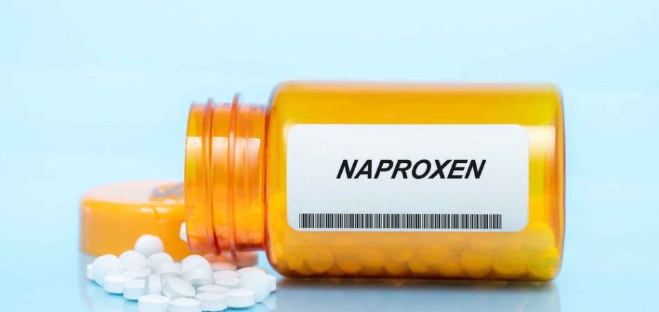 Naproxen pills in a yellow bottle