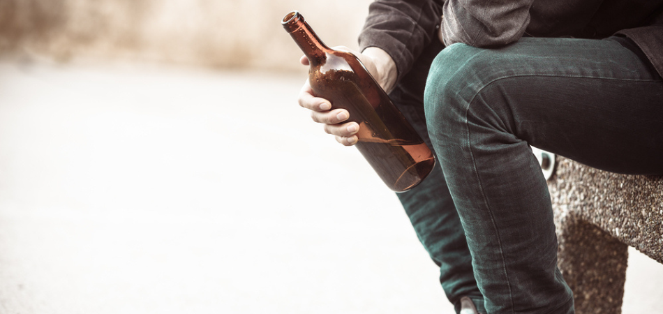 alcoholic man drinking on a bench