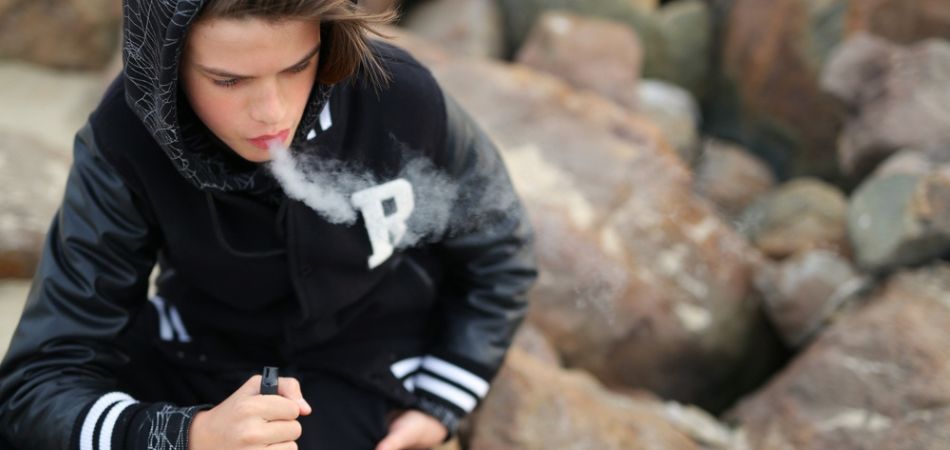 Young boy vaping outside