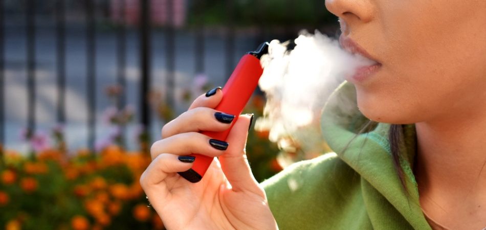Young woman smoking vaping