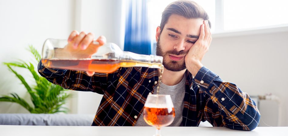 man drinking alcohol at home