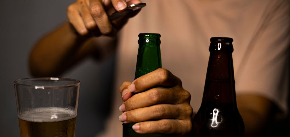 man opening alcohol bottle in hand