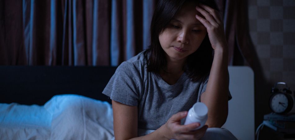 young woman struggeling with sleeping pills