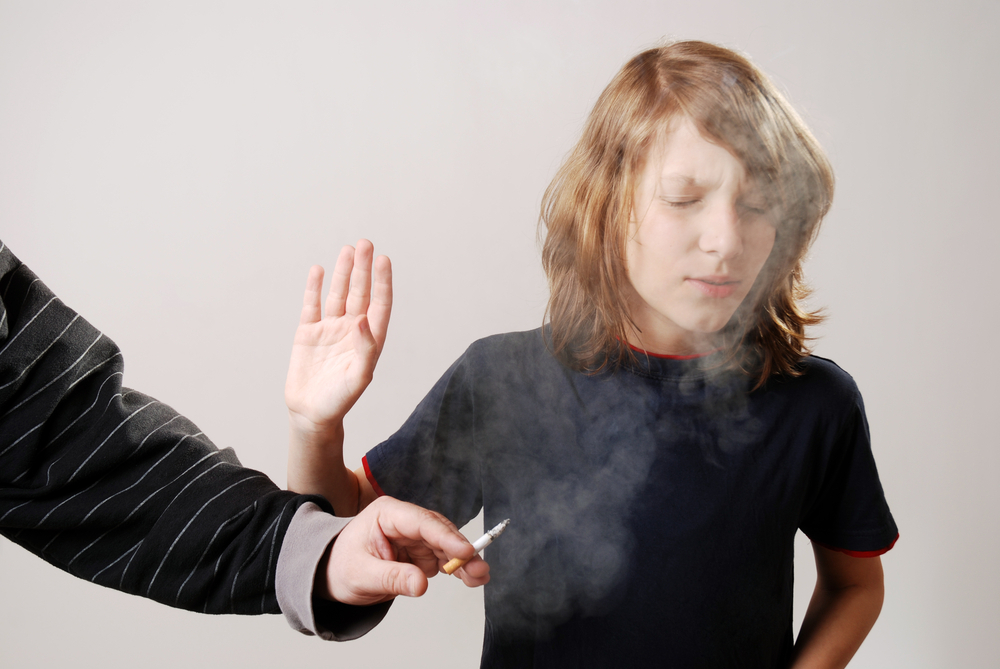 Man smoking infront of young boy