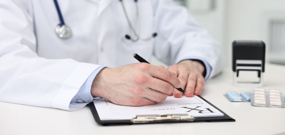 Doctor writing prescription in the table