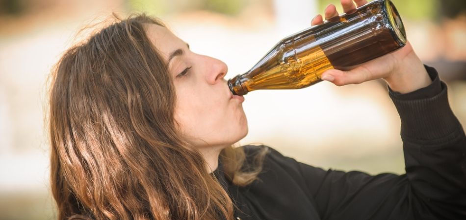 woman drinking alcohol in bottle
