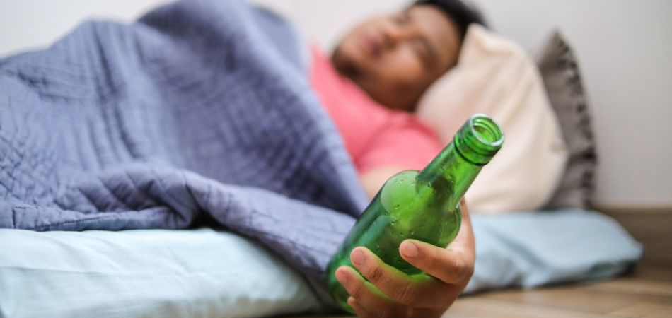 man lying in addiction with alcohol