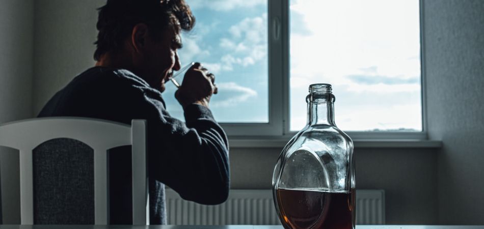 man drinking aocohol at home