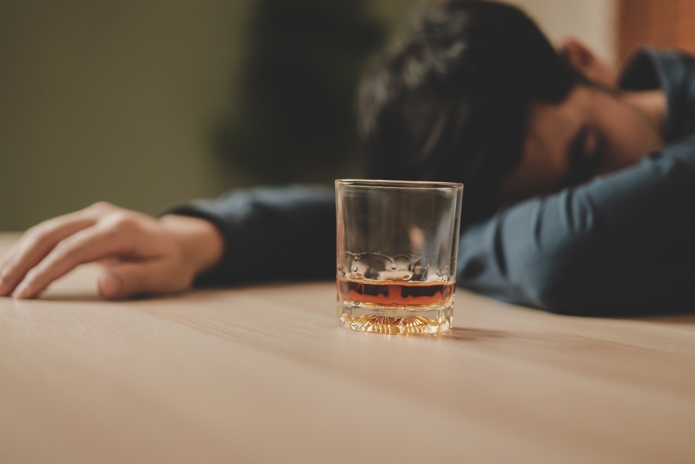 Man in alcohol addiction lying on table