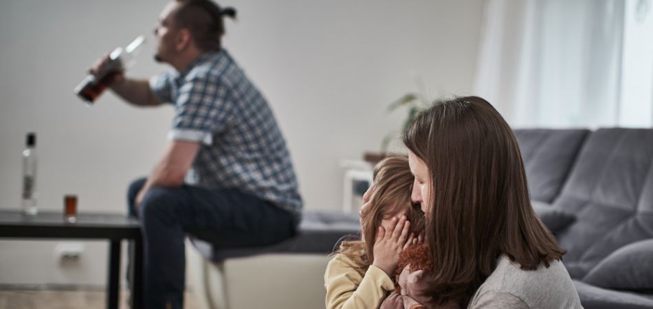 father driking infront of family