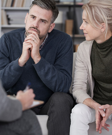 A man and woman talking to a counsellor