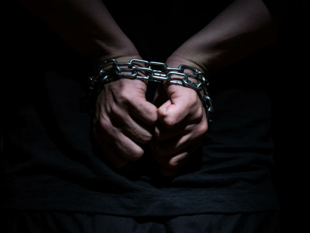 male hands chained to addiction