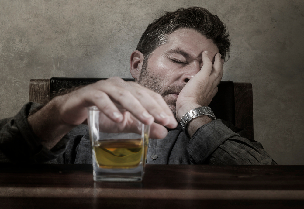 young depressed man drinking alcohol