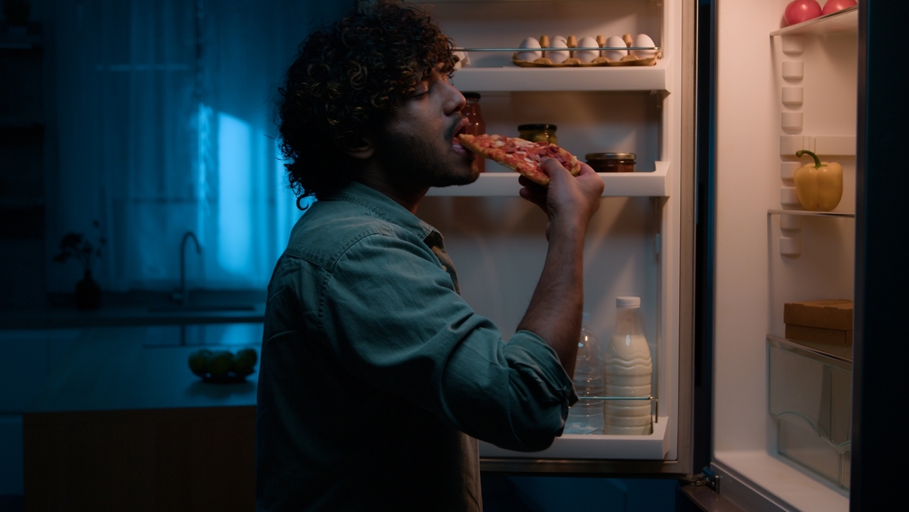 man-eating-pizza-at-night