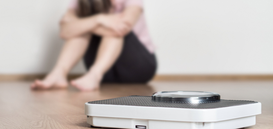 Sad woman by the scales