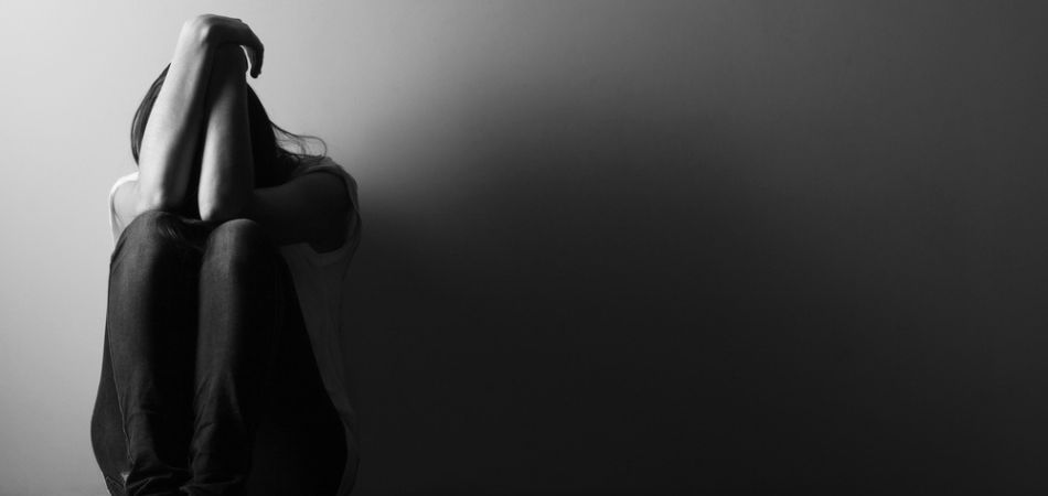 Depressed woman sitting alone in the room